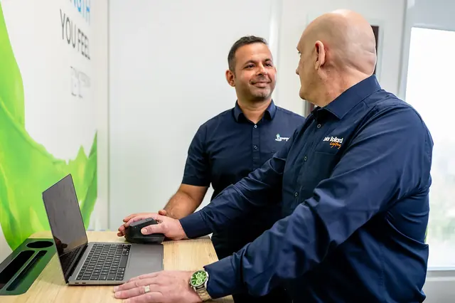 A clinician talking with a patient at a computer workstation