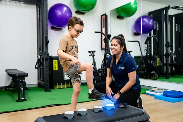 A clinician guiding a child through a movement activity